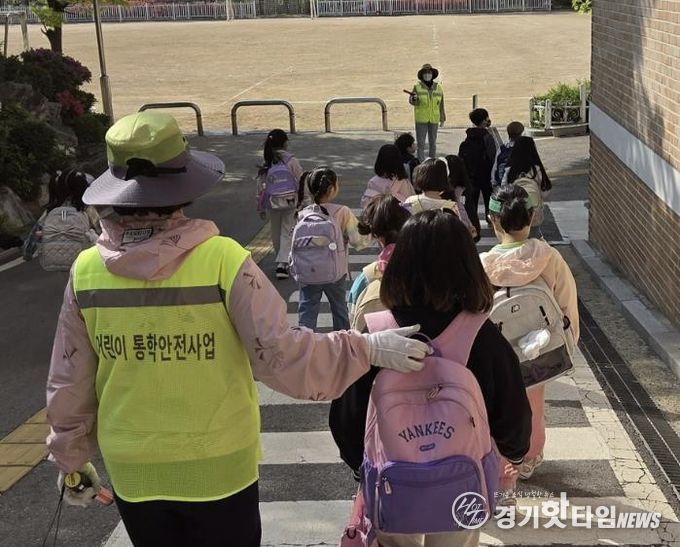 초등학교 학생들이 워킹스쿨버스 안전지도사와 함께 등교하고 있다.